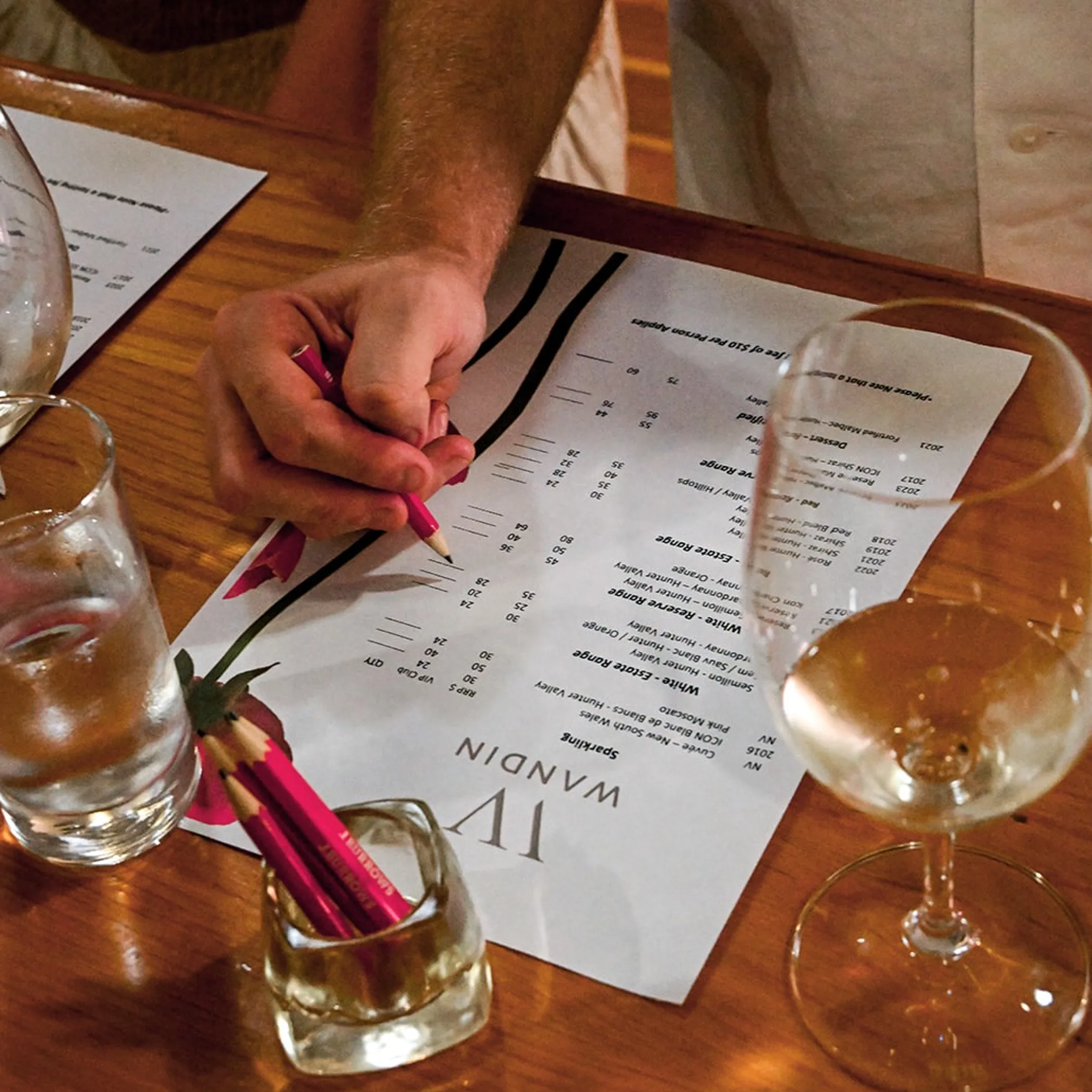 winemaker pouring red wine tasting glass