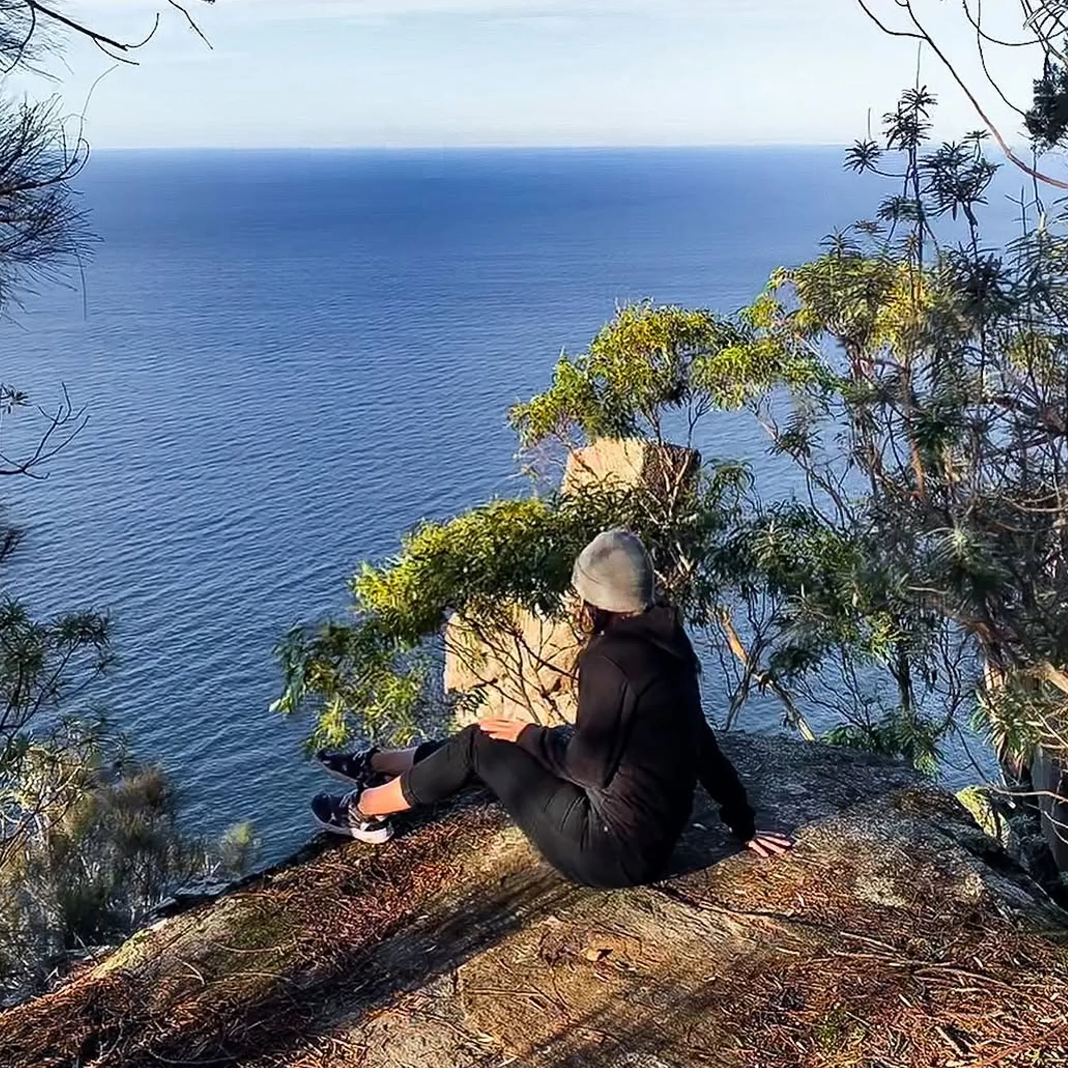 hiker overlooking tasmanian coastal wilderness