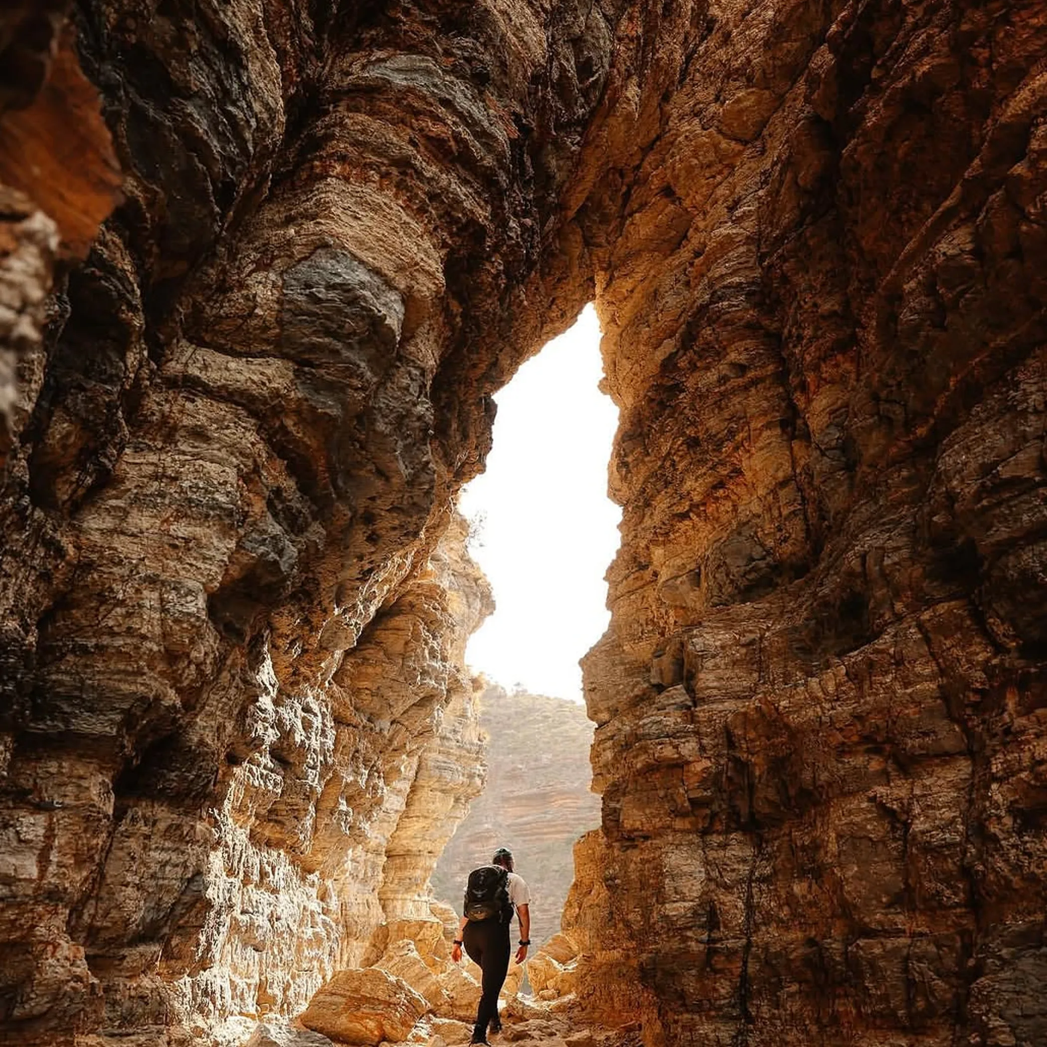 hiker navigating natural rock passage